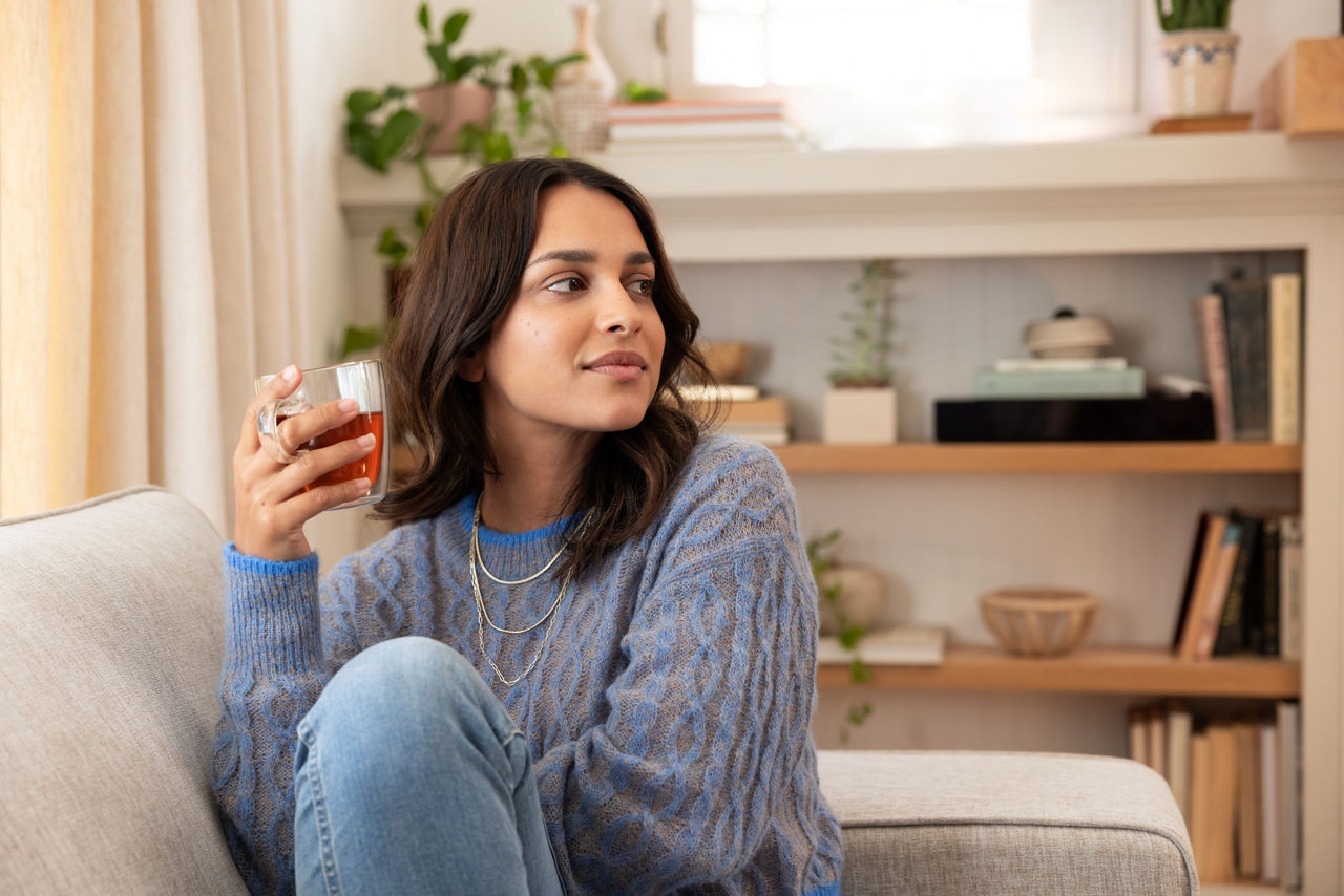 Young Woman Drinking Herbalife Tea on a Sofa