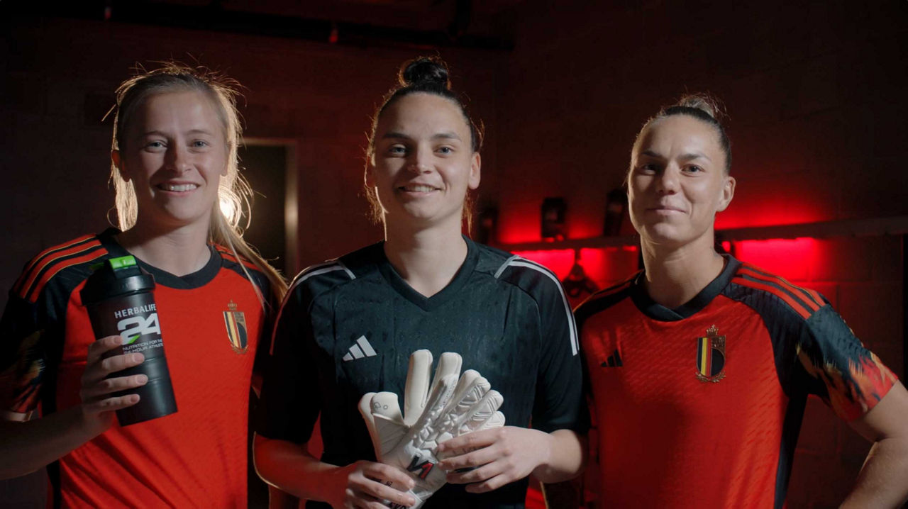 Een foto van drie leden van de door Herbalife gesponsorde Red Flames, het Belgische nationale vrouwenvoetbalteam.