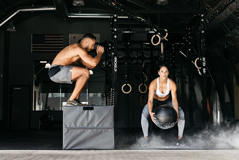 Kaksi urheilijaa tekemÃ¤ssÃ¤ kestÃ¤vyystreeniÃ¤ kuntosalilla