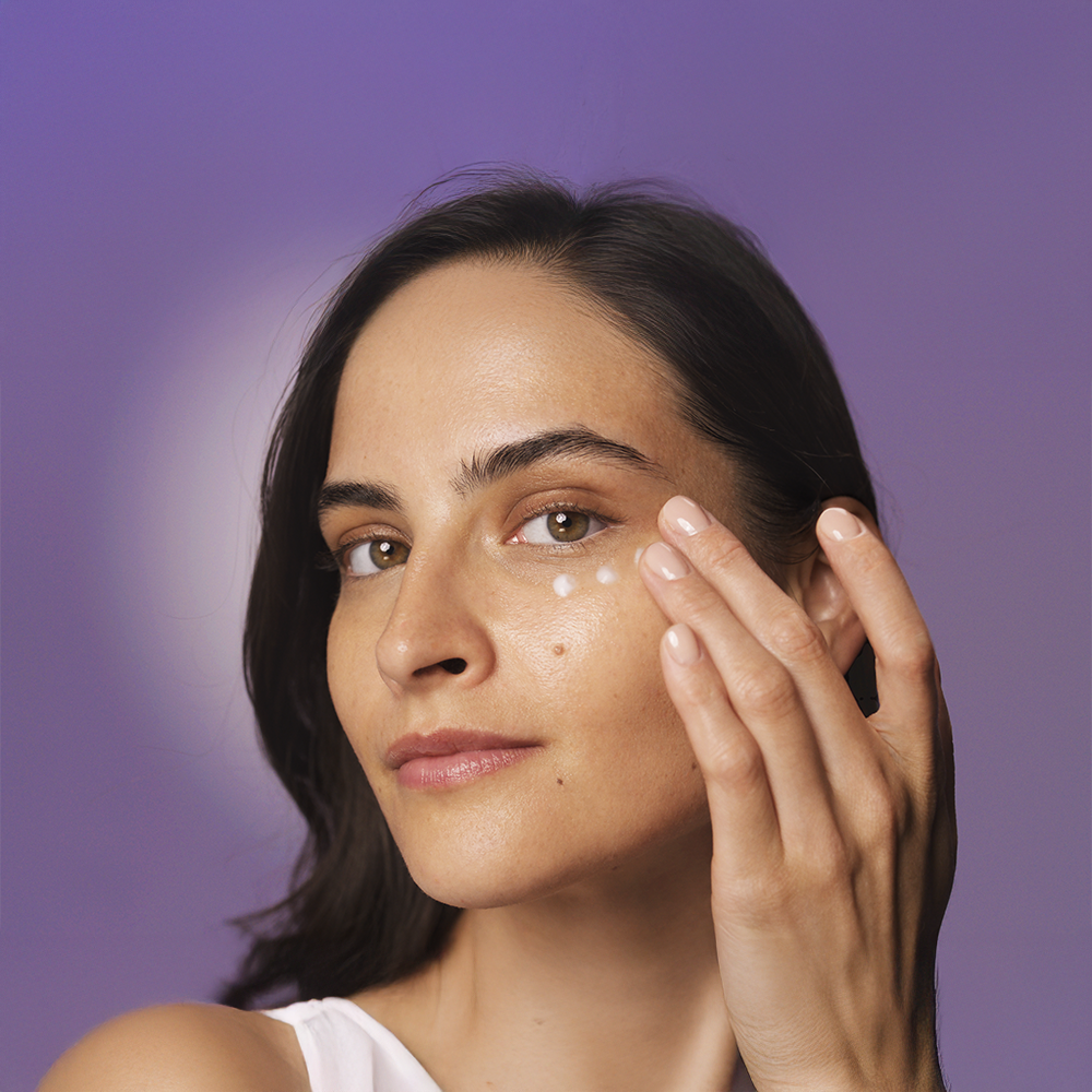 Μια γυναίκα εφαρμόζει την HL/Skin Nourishing Eye Cream στο πρόσωπό της.