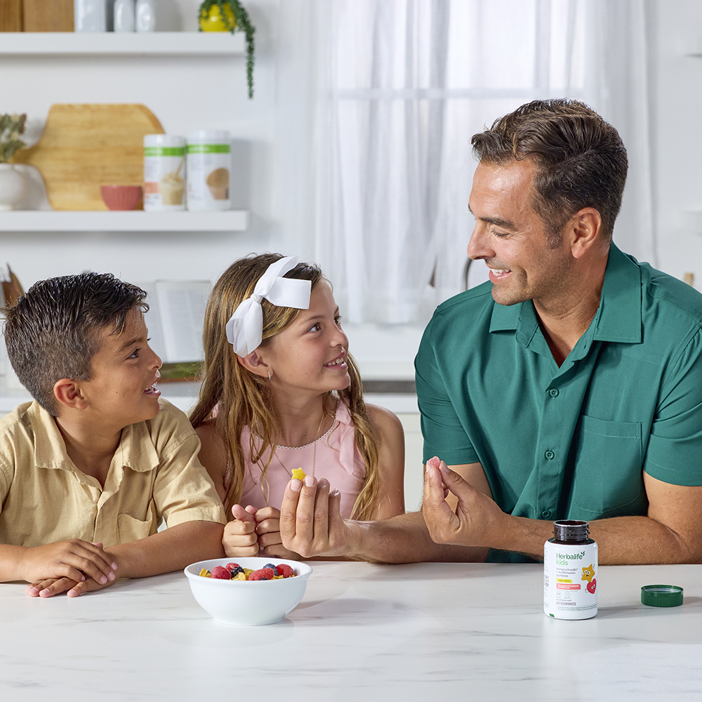 A father shows kids gummies in the kitchen