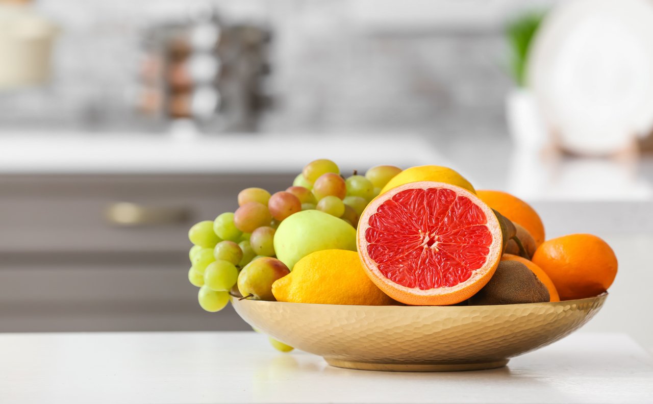 Plate with different fruits on kitchen table