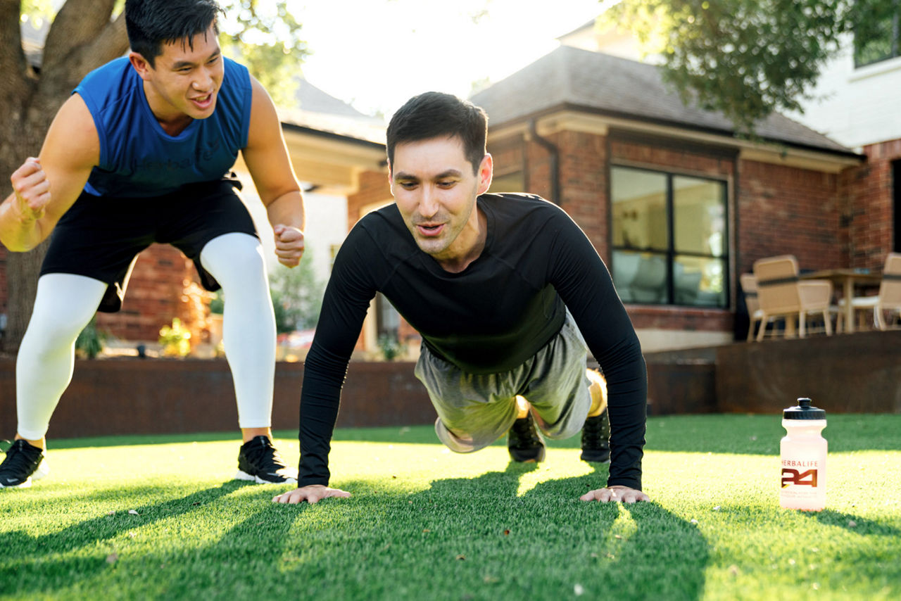 A fitness coach training a client through push-ups.