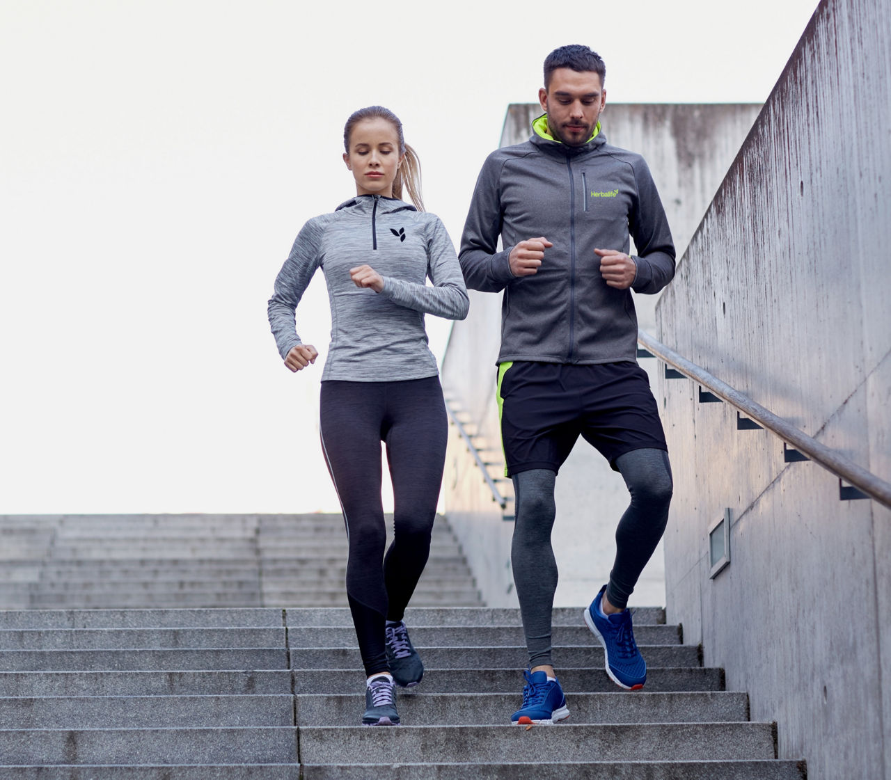 Couple running together down a flight of stairs at an outdoor location