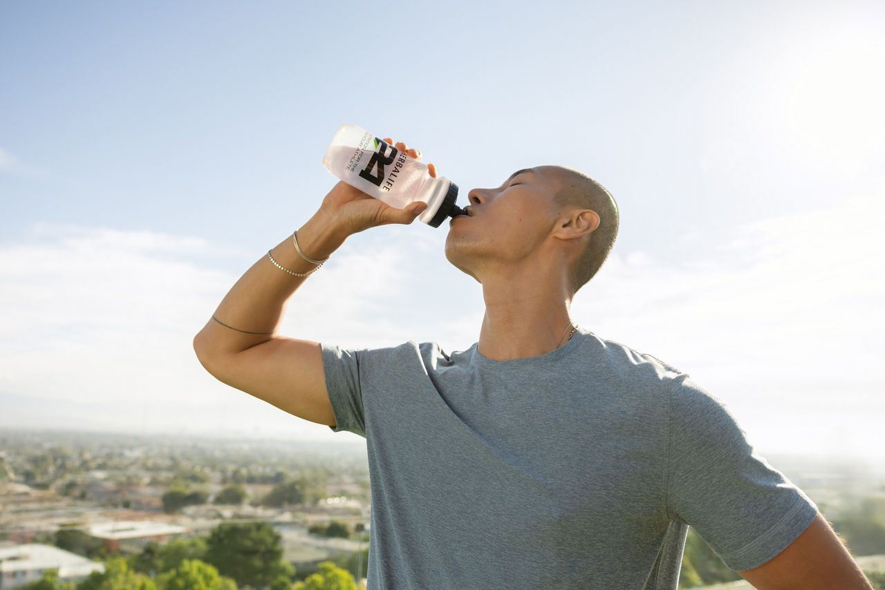 Man having a drink after exercising outdoors.