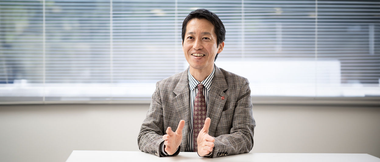 Masashi Miyashita, NAB member from Japan, smiles while sitting at a table