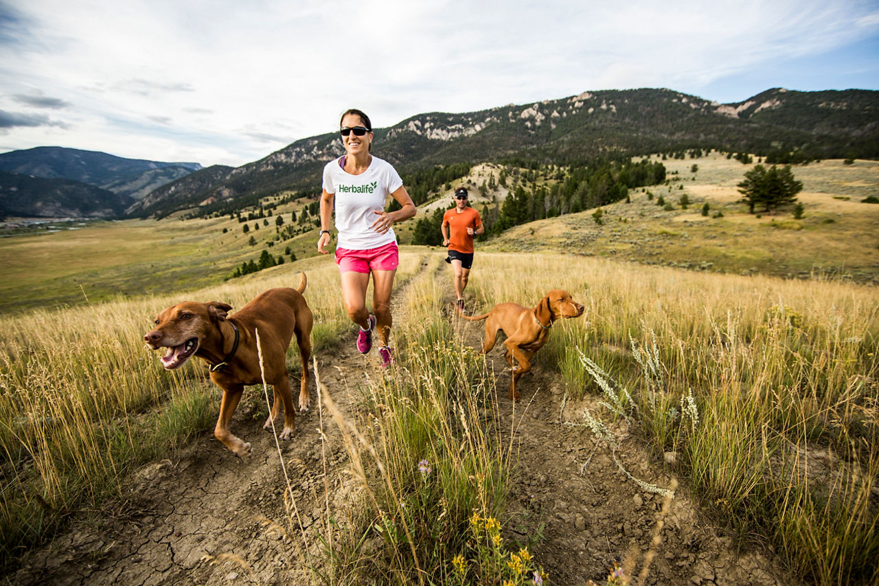 Couple running with their dogs on a trail in Big Sky Country, Trail running in Big Sky with dogs