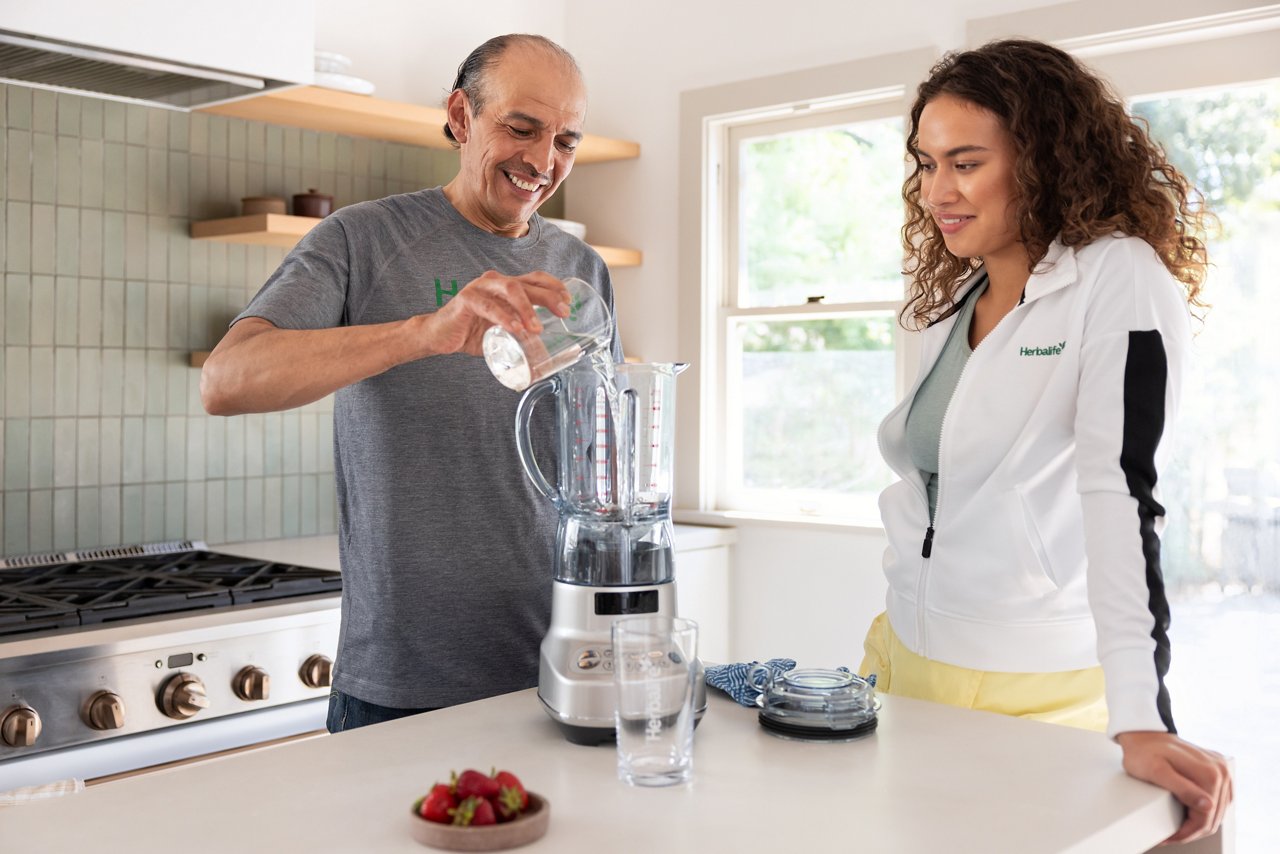 Man and woman blending a Formula 1 Shake in the kitchen.