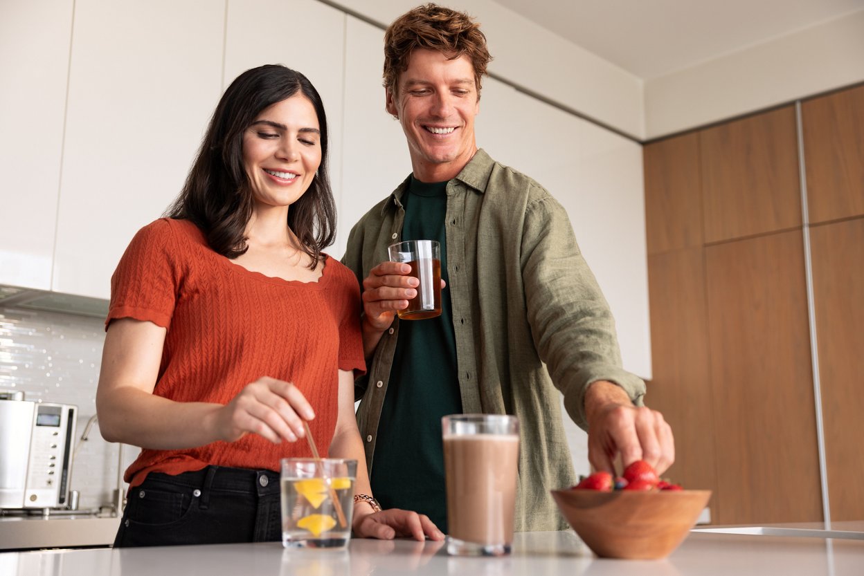 Couple relaxing with drinks in their home.