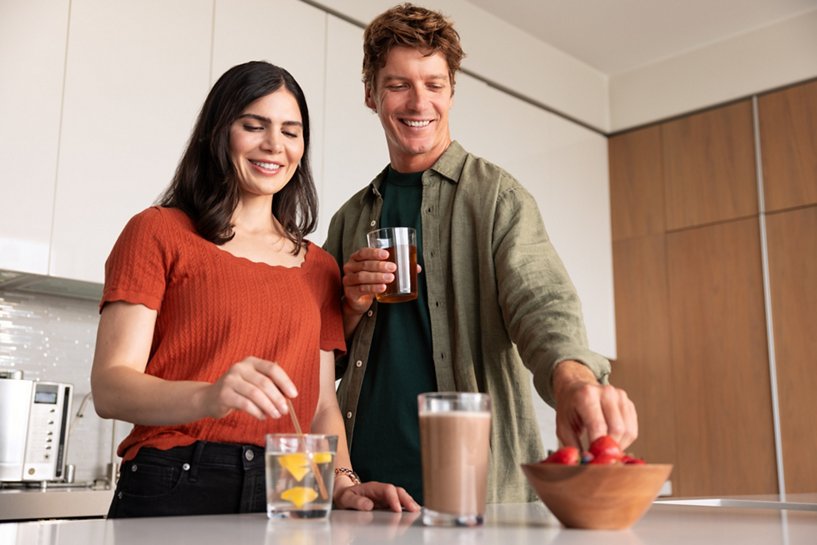 Couple relaxing with drinks in their home.