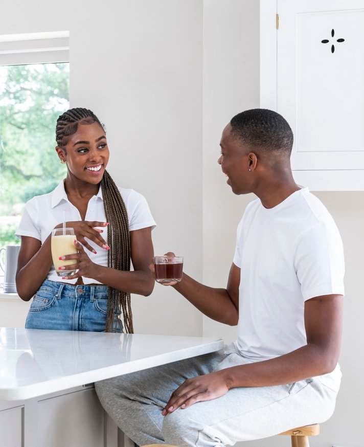 Couple having shake and tea in their kitchen
