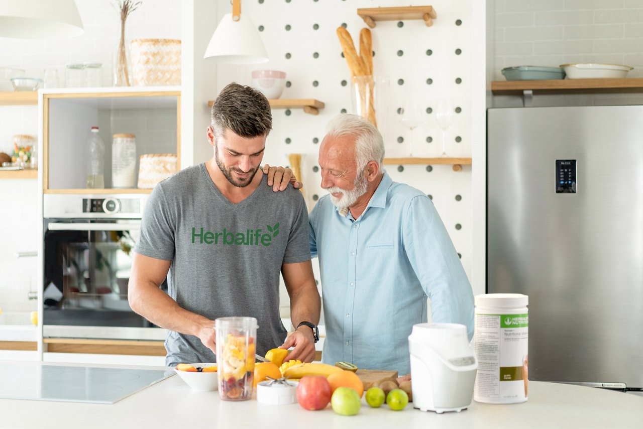 Father and son making an Herbalife Formula 1 protein shake in the kitchen.