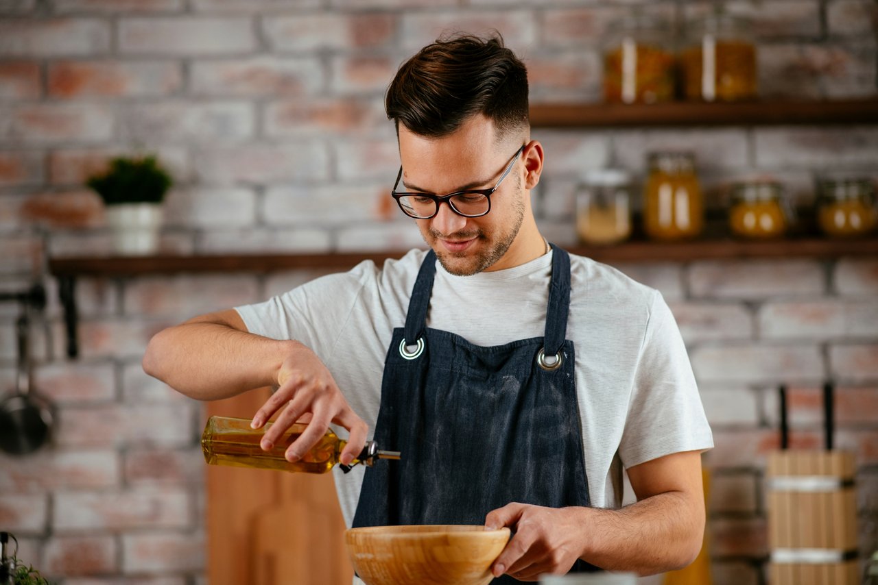 Handsome chef cooking. Young man making food., Handsome chef cooking. Young man making food.
