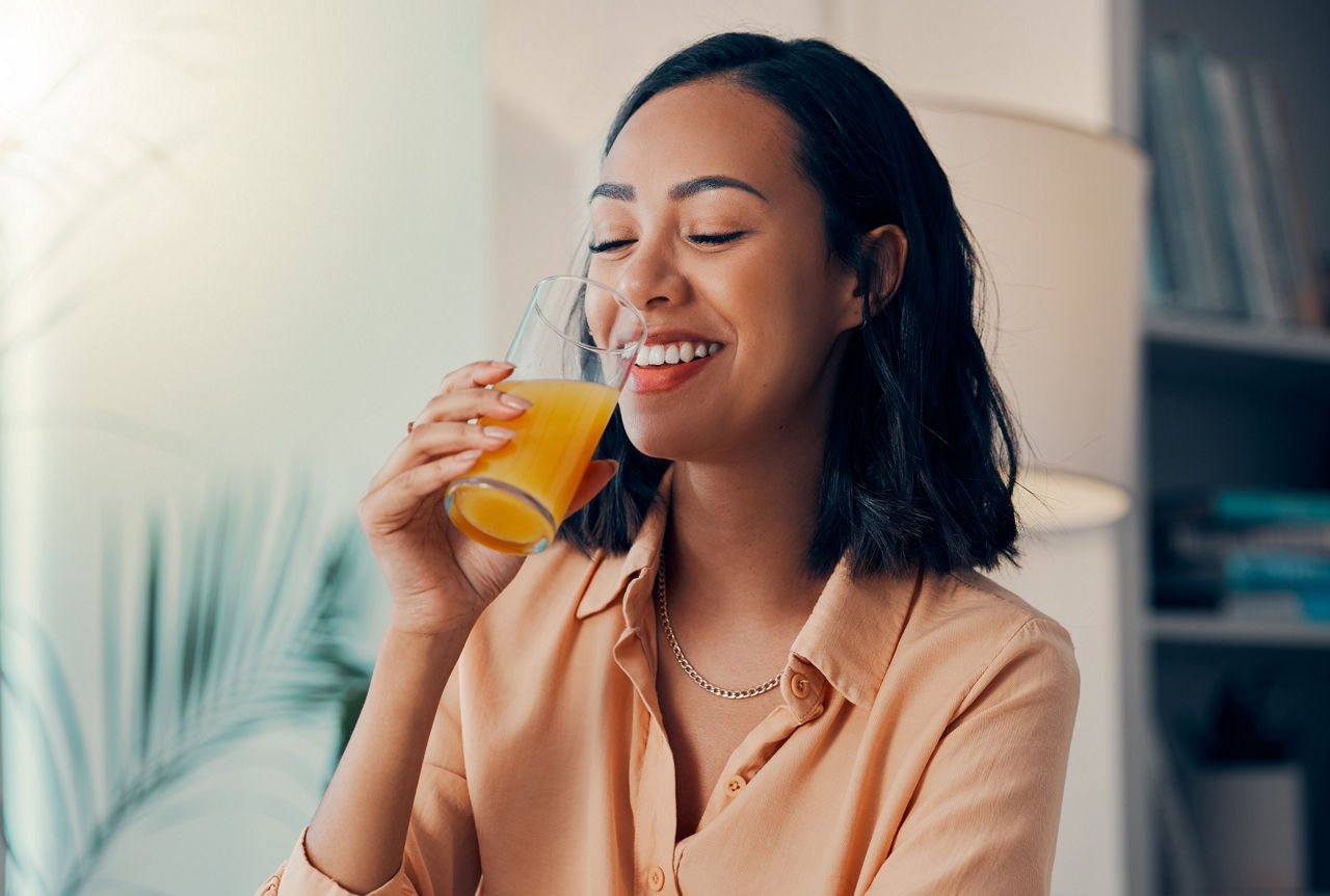 Orange juice, drink and happy black woman relax while drinking health liquid or organic fruit beverage. Happiness, smile and thirsty nutritionist girl with glass of juice for wellness and hydration.