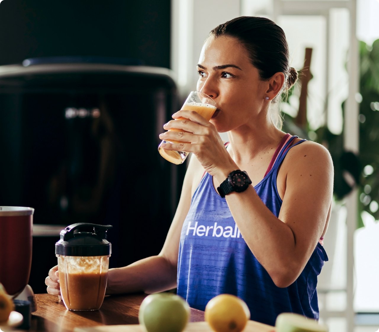 Woman drinking fruit juice in her kitchen