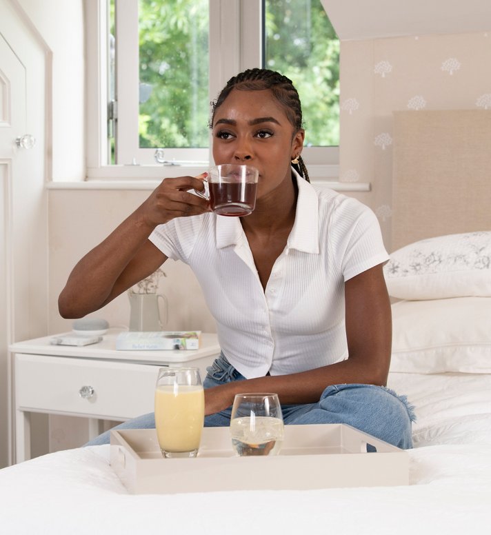A woman enjoying Herbalife breakfast in bed