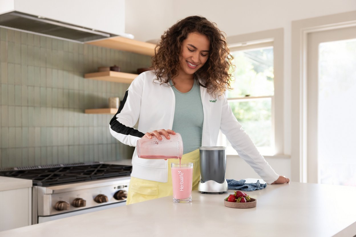 Woman pouring Wildberry shake