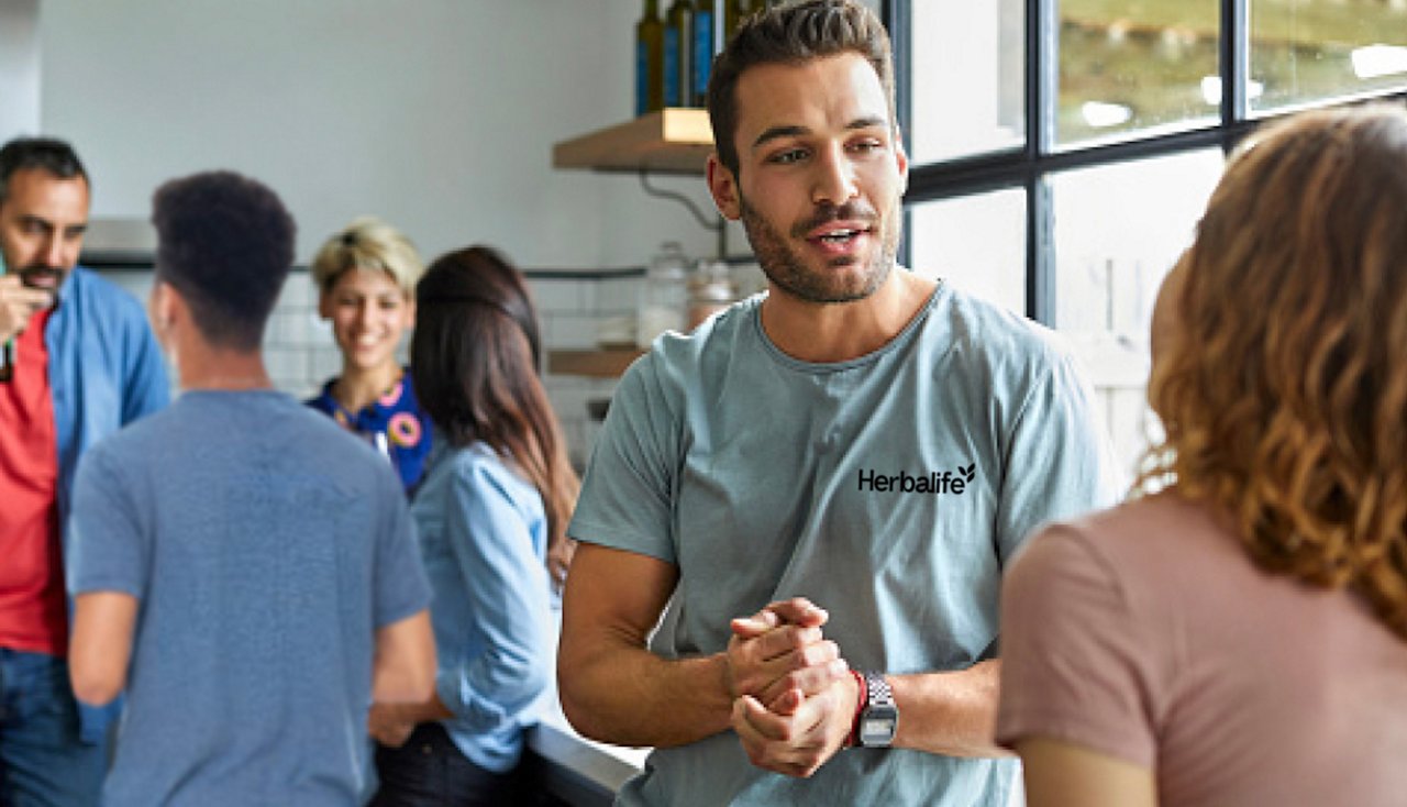 Man speaking with a woman about business opportunities at a Nutrition Club event, Man speaking with a woman about business opportunities at a Nutrition Club event