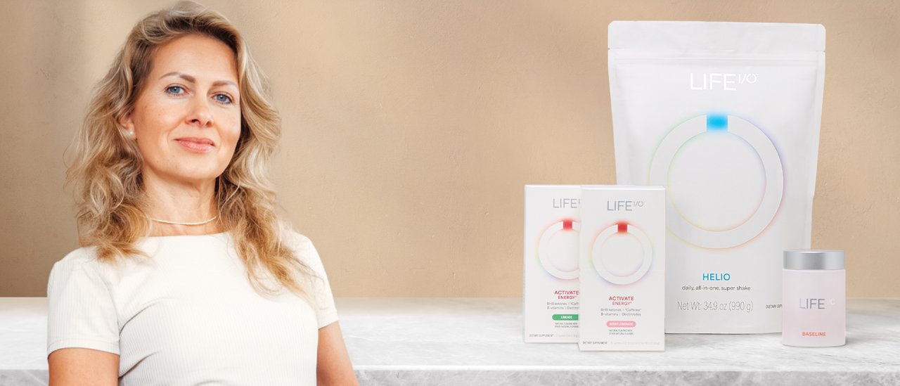 Person in a white top standing beside wellness products.