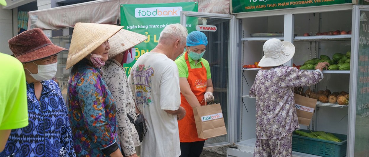 Group of people lining up to receive food from The Global FoodBanking