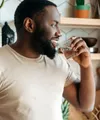 Man drinking out of a glass in the kitchen
