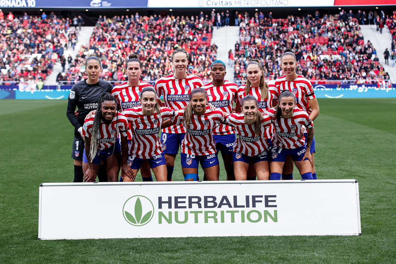 Equipo del Atlético de Madrid Femenino en el campo con equipación de la marca Herbalife
