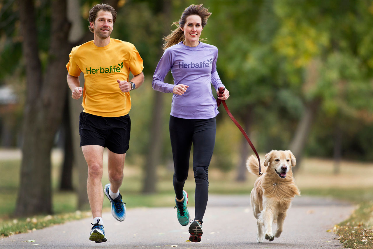 Couple running with dog