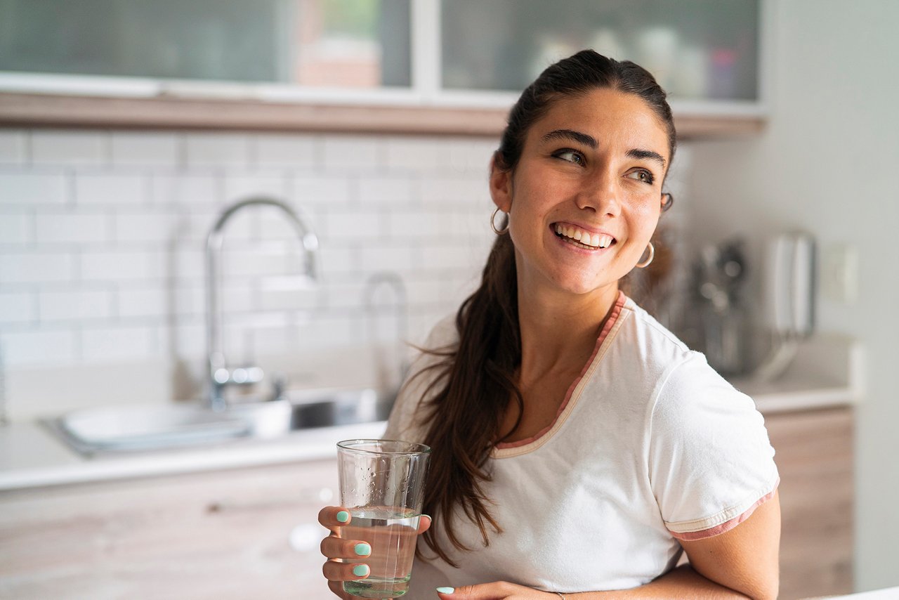 Woman holding a glass in kitchen