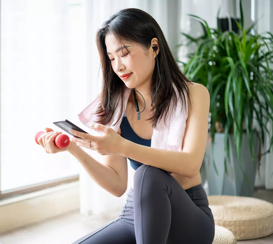 Woman exercising while checking her phone