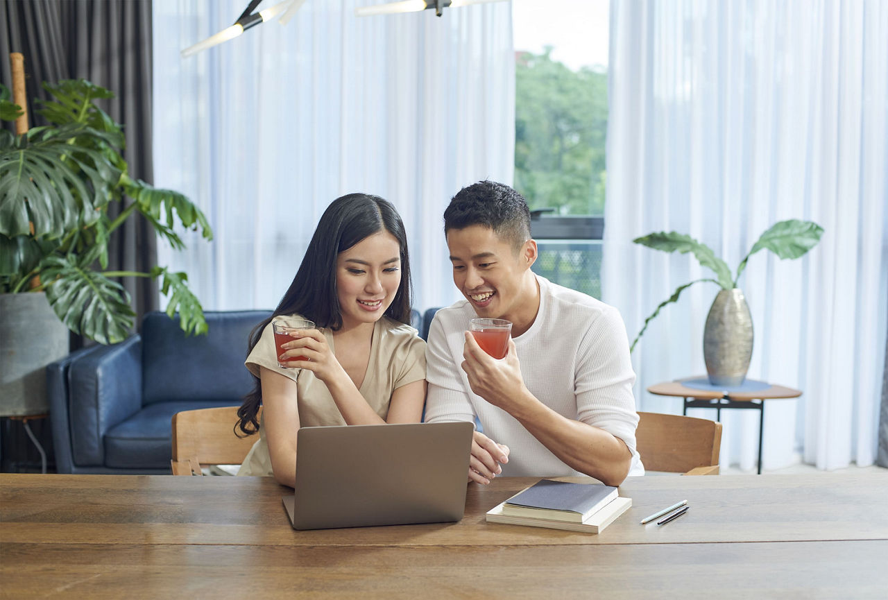 Couple enjoying an ImmuLift beverage while working on their laptop computer