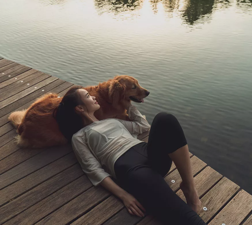 Woman relaxing with her dog on the docks