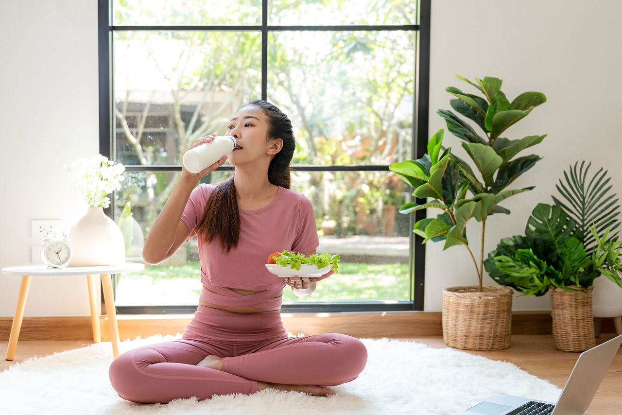 Woman drinking milk and eating a salad