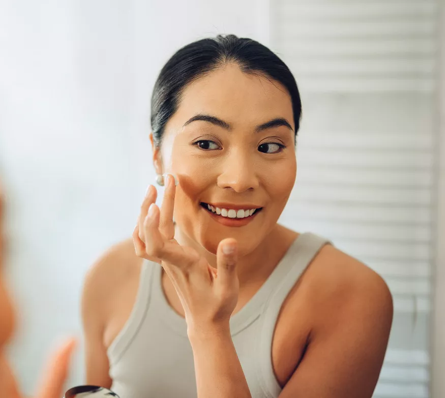 Woman applying facial moisturizer