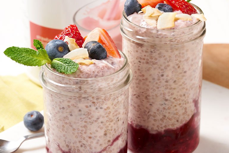 Dvije tegle pudinga od chia sjemenki i šumskog voća s borovnicama i jagodama na vrhu