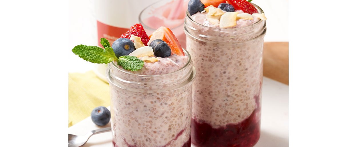 Dvije tegle pudinga od chia sjemenki i šumskog voća s borovnicama i jagodama na vrhu