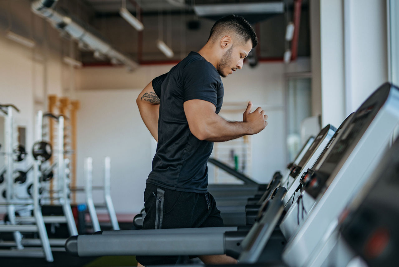 Homme courant sur un tapis roulant lors d'un entraînement de fitness