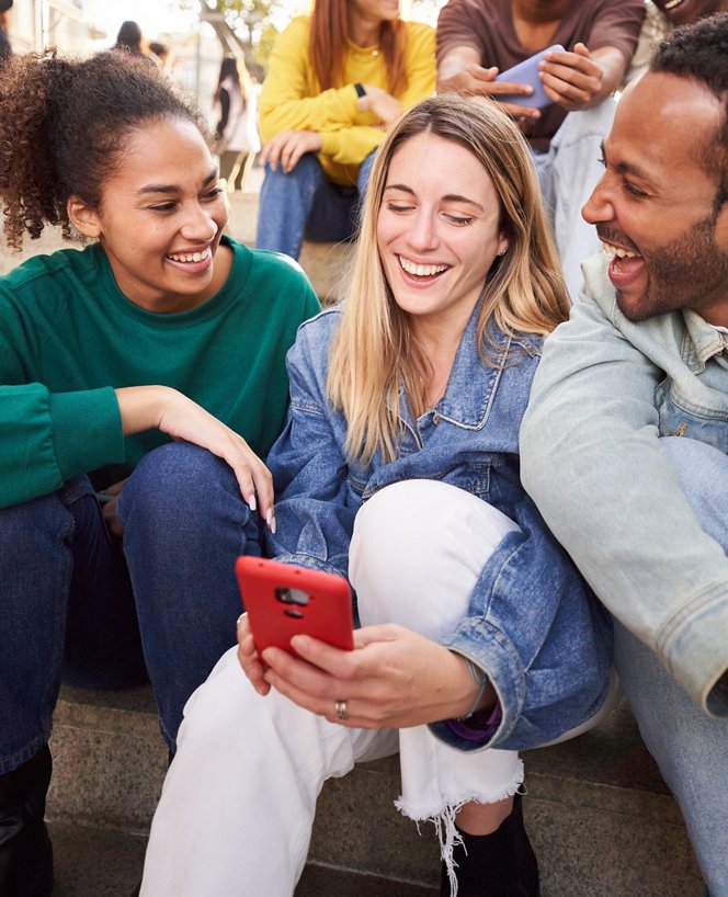 Amis regardant un téléphone à l'extérieur