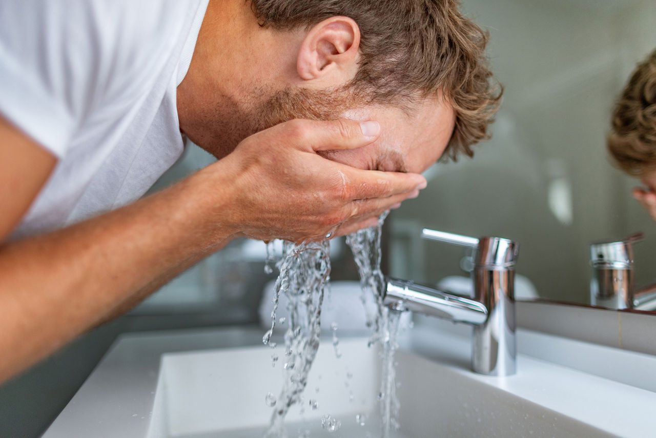 Man washing his face in the morning