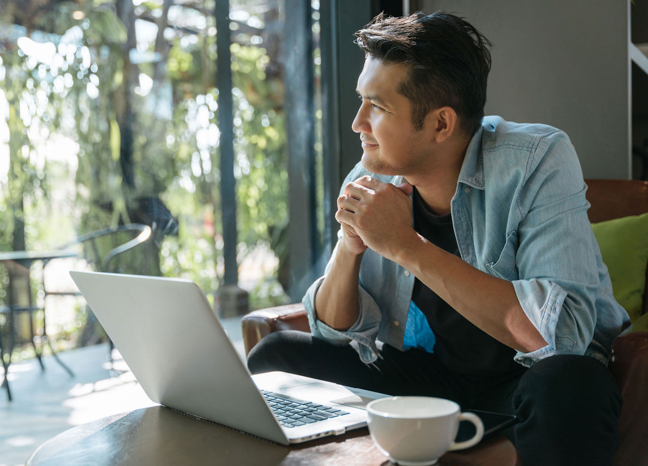 Homme prenant une pause au travail et regardant par la fenêtre