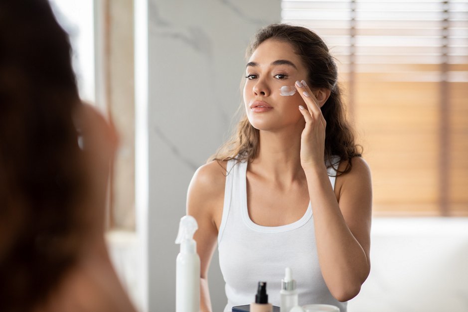 mujer aplicándose crema hidratante
