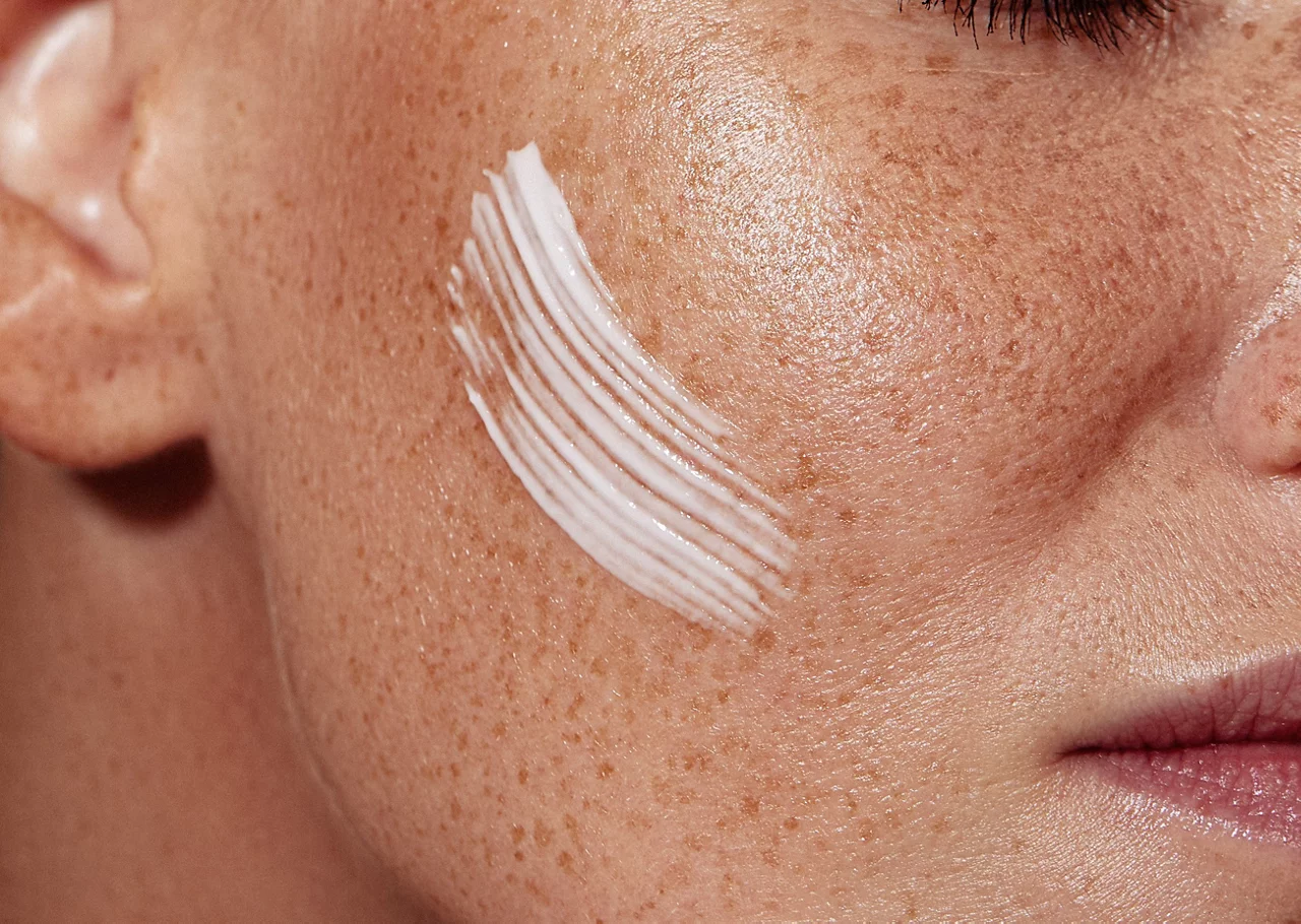 Mujer aplicándose crema solar