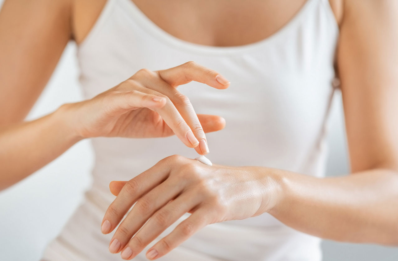 Woman putting a cream on her hands