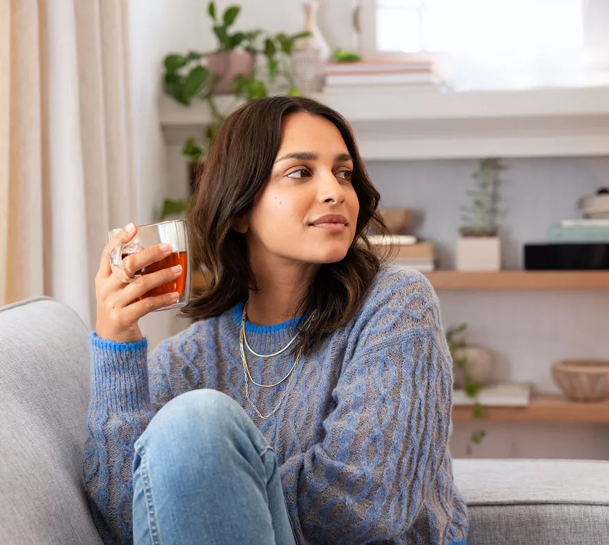 Woman at home holding cup of tea