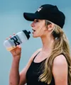 Woman drinking sports drink outdoors