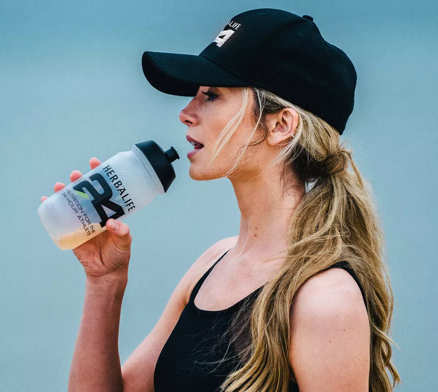 Woman drinking sports drink outdoors