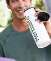 man drinking protein shake park