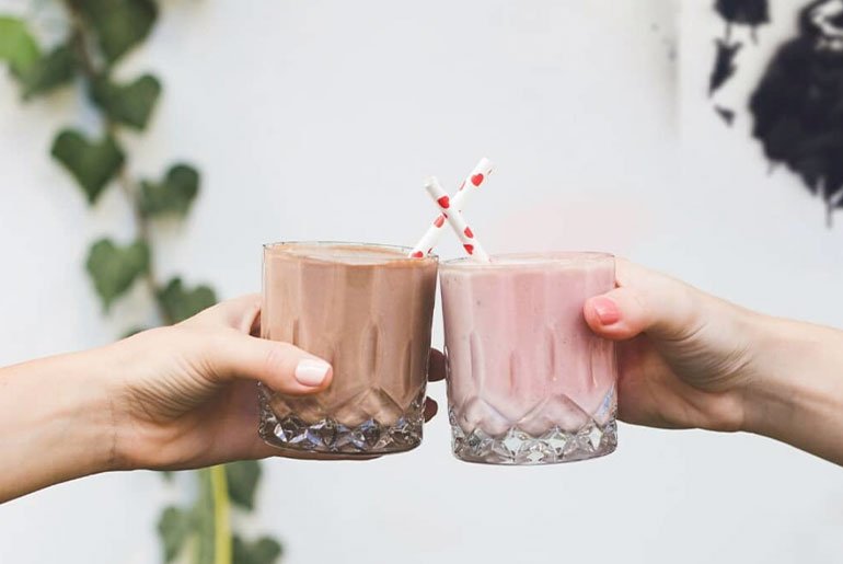 To personer som holder glass med Formula 1-proteinshake