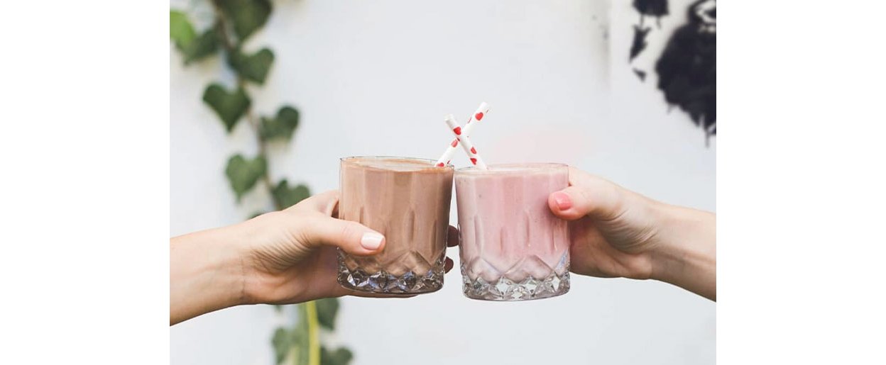 To personer som holder glass med Formula 1-proteinshake