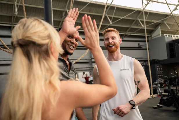 Group celebrating doing hi five after a workout.