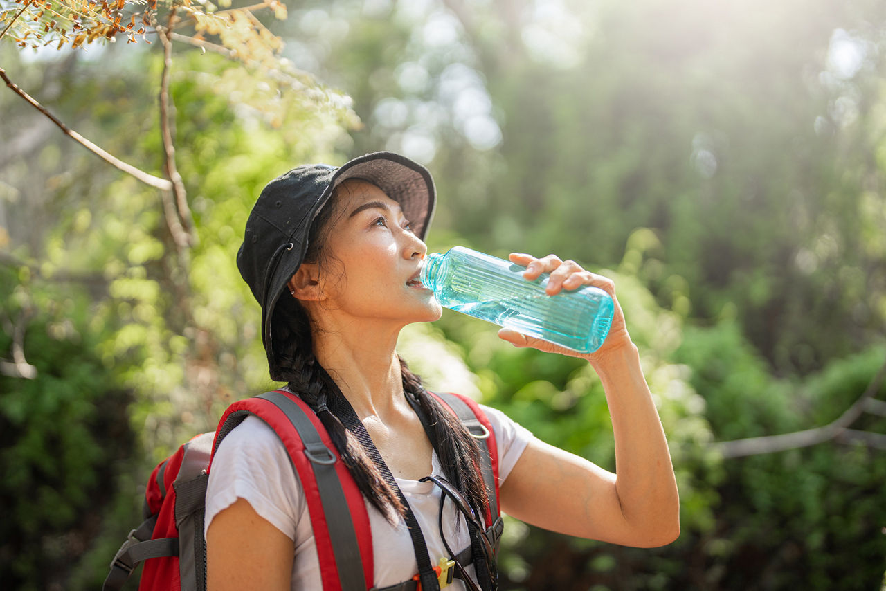 Woman drinking water while hiking